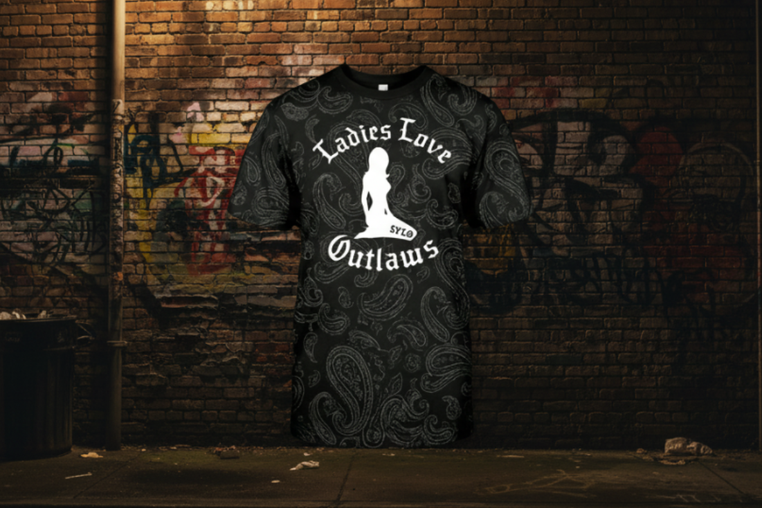 Black t-shirt with white graphic of kneeling lady and Ladies Love Outlaws on a black background with subtle paisley design